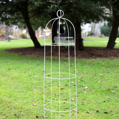 Elegance Orb obelisk sat in a large areas of grass with trees behind