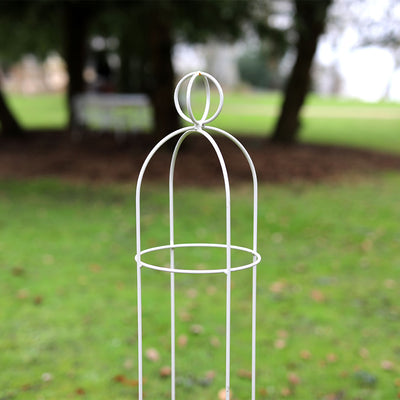 Partial close up of Elegance Orb Obelisk in large area of grass with trees in the background